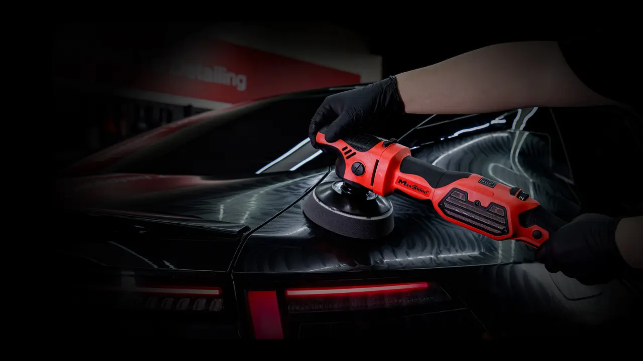 Polidora rotativa MaxShine MB1200 Pro a polir a traseira de um carro preto numa oficina de detailing